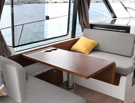 A bâbord le coin repas du carré avec deux banquettes en face à face se convertit en couchette pour la nuit. Nautisme Article