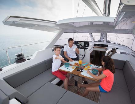 Confortablement installé sous la casquette de roof, qui intègre dorénavant une table pour huit personnes, vous découvrez sur la console les commandes qui permettent de dérouler les voiles sans quitter la barre. Nautisme Article