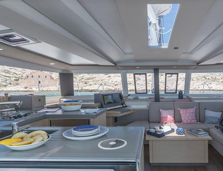 A l'intérieur, le salon séduit par ses larges vitrages sur 360° offrant une grande luminosité. La cuisine en forme de U communique directement avec le cockpit via une large baie. Nautisme Article