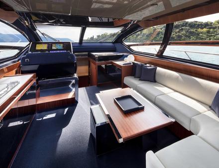 Sur le pont principal, le salon comporte de larges ouvertures et une grande banquette en L avec toujours un style high-tech. Nautisme Article