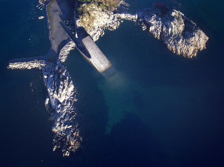 La forme monolithique du bâtiment vient s'adosser au rivage et plonge jusqu'à 5 mètres de profondeur dans les eaux froides de la mer du Nord.