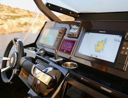 Recouverte par un T-top, la console centrale de l'Omega 45 propose un poste de pilotage avec écrans de contrôle et joystick pour les manoeuvres au port. Nautisme Article