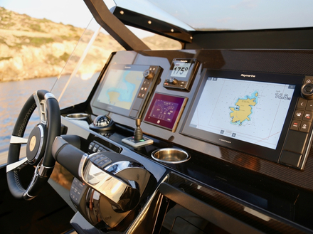 Recouverte par un T-top, la console centrale de l'Omega 45 propose un poste de pilotage avec écrans de contrôle et joystick pour les manoeuvres au port. Nautisme Article