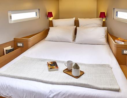 Afin de jouir d'une belle salle de bains, le lit rectangulaire de la cabine avant est placé diagonalement, libérant ainsi de grands équipets en tête de lit. Nautisme Article