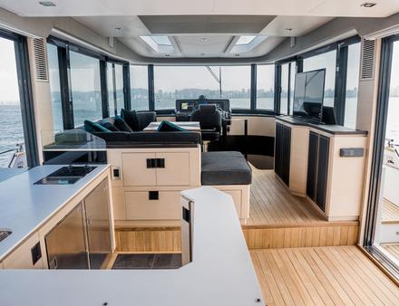 Le 50 Fly dispose de larges ouvertures latérales et de grandes baies vitrées, sans oublier un système de balcons ouvrables qui élargit la surface du carré au mouillage. Nautisme Article