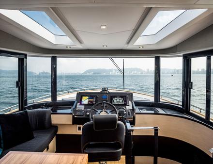 Facilement accessible, le flybridge dispose d'un poste de pilotage, d'une banquette en L asymétrique, d'un large bain de soleil, le tout surplombé par un hard-top noir moderne. Nautisme Article