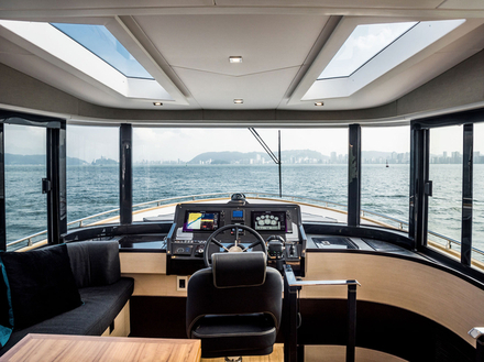 Facilement accessible, le flybridge dispose d'un poste de pilotage, d'une banquette en L asymétrique, d'un large bain de soleil, le tout surplombé par un hard-top noir moderne. Nautisme Article