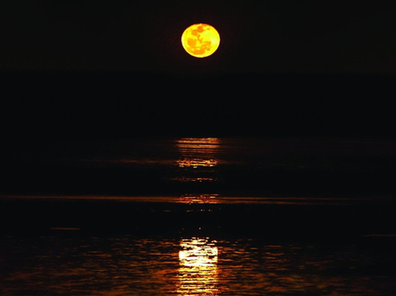 La pleine Lune se lève sur l'océan indien à marée basse et crée l'illusion de pouvoir atteindre le satellite par un escalier.
