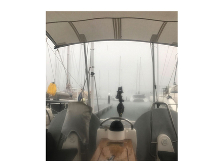 Sous la pluie de décembre en Martinique. On aperçoit la latte jonc de la chute dans son gousset reprise sur les deux tubes en aluminium fichés dans des portes cannes fixés au balcon arrière Nautisme Article