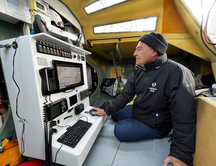 Jean-Pierre Balmes à l'intérieur de son Class 40. Notez le casque à visière au-dessus de la table à cartes. - Nautisme Article