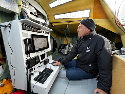 Jean-Pierre Balmes à l'intérieur de son Class 40. Notez le casque à visière au-dessus de la table à cartes. - 