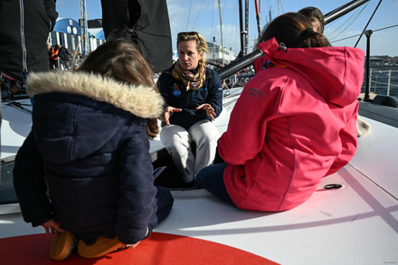 La skipper française Éloïde Bonafous (au centre) accueille des enfants à bord de son IMOCA La skipper française Éloïde Bonafous (au centre) accueille des enfants à bord de son IMOCA